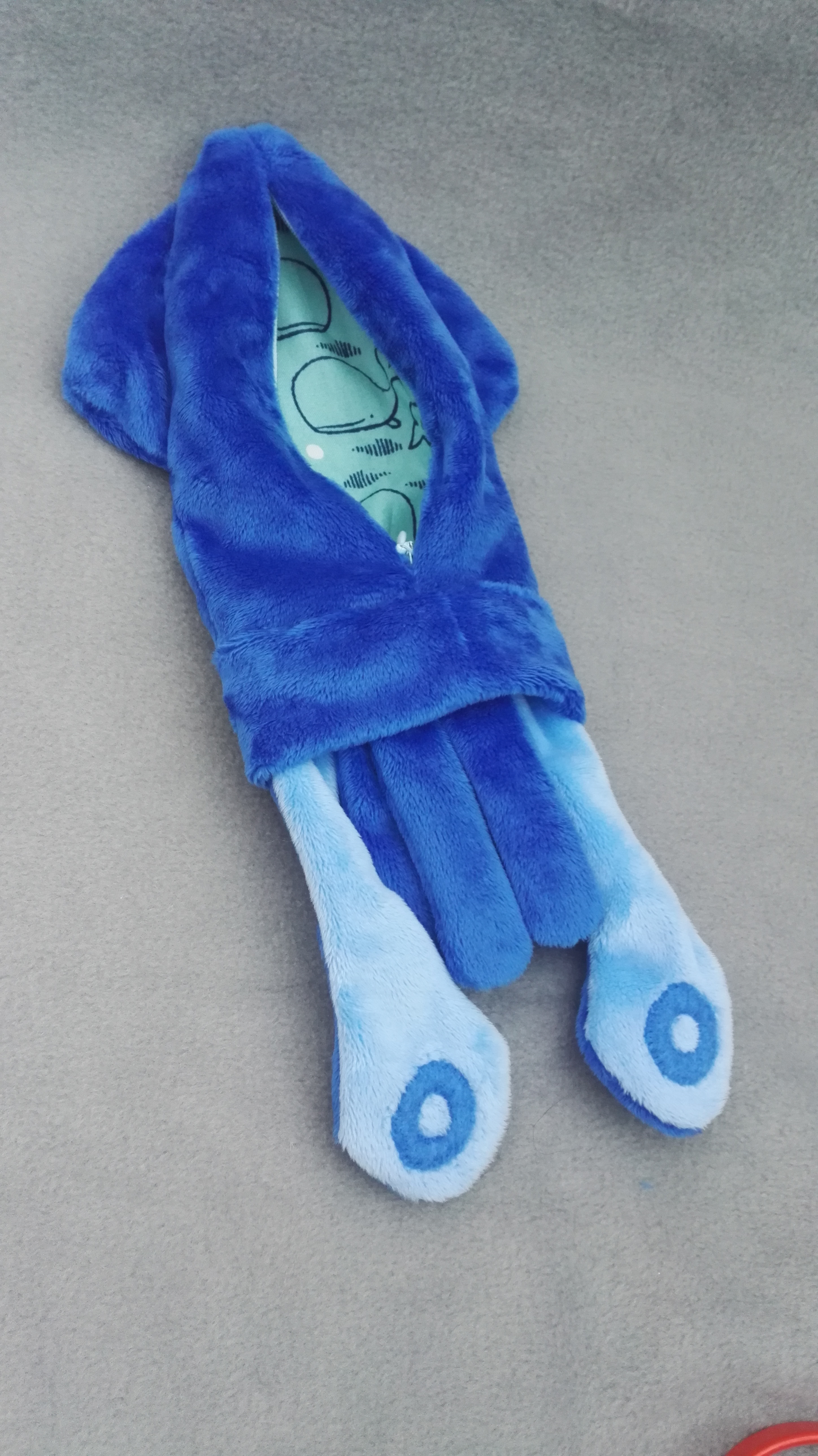 the reverse of the blue squid pouch, showing off the light blue tentacle side and cotton lining with whales on it